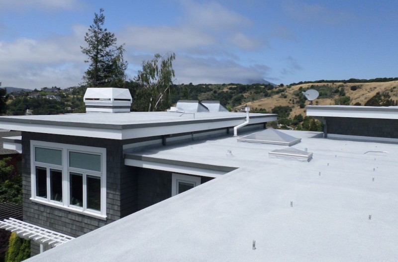 White-coated flat roof on a residential home designed to reflect heat in a hot desert climate.